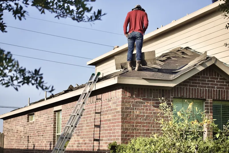 Professional roofer working on a residential roof in HIghland Park